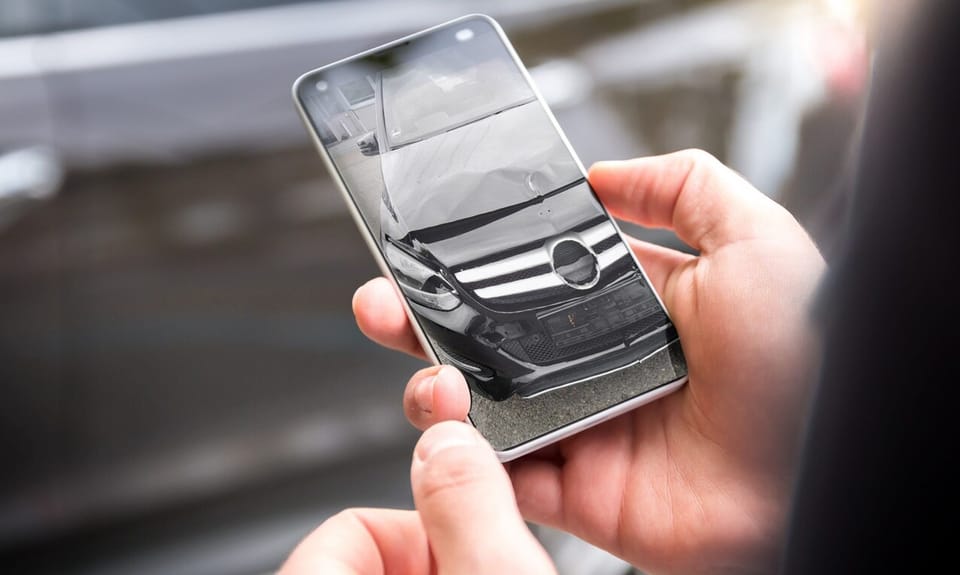 Fahrzeugschaden wird mit dem Smartphone für die Schadenmeldung fotografiert